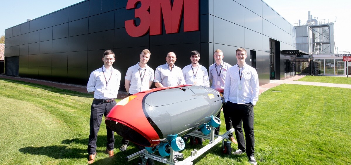 Team stand outside 3M building
