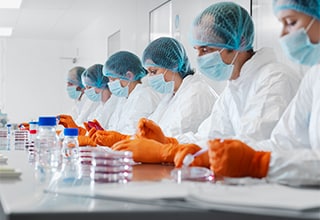 Stock image of scientists running tests in petri dishes