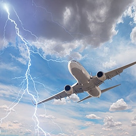 An airplane in the air with a lightning strike next to it.