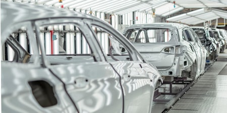 A row of automotive chassis on the assembly line.
