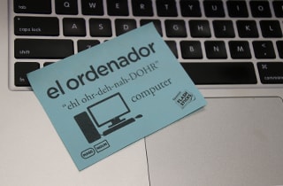 Image of FlashSticks, a product inspired by learning a new language through writing translations on Post-It Notes, on a computer keyboard.