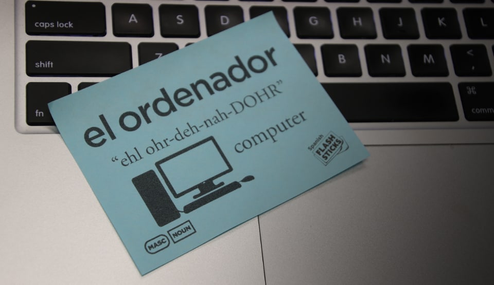 Image of FlashSticks, a product inspired by learning a new language through writing translations on Post-It Notes, on a computer keyboard.