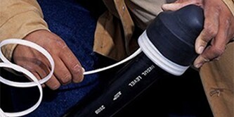 Hands demonstrating the use of 3M Heat Shrink end caps
