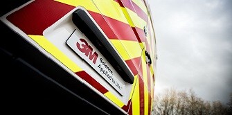 Person applying reflective chevron markings to a van
