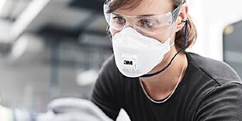 Person wearing safety goggles and respirator
