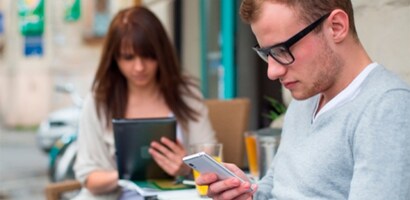 Man and woman looking at their devices in a cafe

