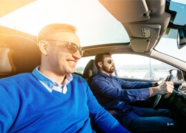 Panoramic sunroof in light-filled interior cabin of car with male driver and passenger