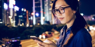woman looking at phone over city skyline
