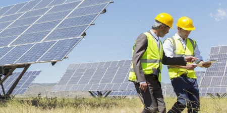 workers in front of solar array
