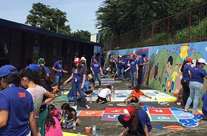 Volunteers with the 3M Global Service Center in Costa Rica painting a mural at a local school.