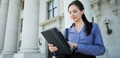Woman on a tablet in front of a government building
