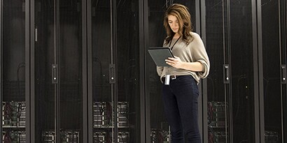 Mixed-race businesswoman using tablet in server room

