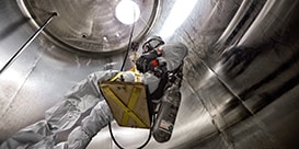 worker checking a confined space

