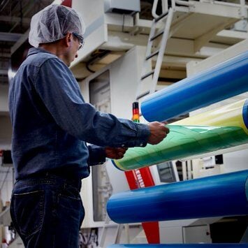 Image of a worker removing a flexographic plate from a flexographic plate on a cylinder