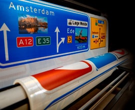 Person on laptop and road sign sheeting printer