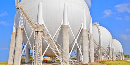 Cryogenic storage containers in a field.
