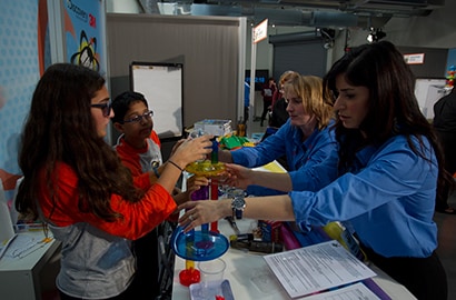 Raha Been, 3M scientist, works with finalists during the Discovery Education 3M Young Scientist Challenge.