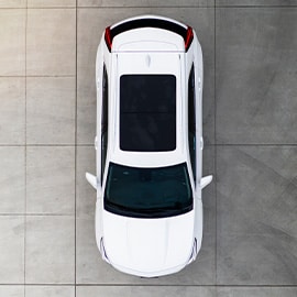 Birds eye view of a white SUV on a concrete slab