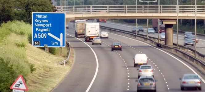 Traffic on a highway with a large road sign
