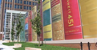 Looking up from the sidewalk, a view of the Kansas City Central Library car park. Wrapped in 3M Controltac Graphic Film, this car park appears to be a line of giant books.