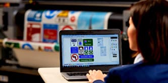 Person using a laptop with traffic sign printer
