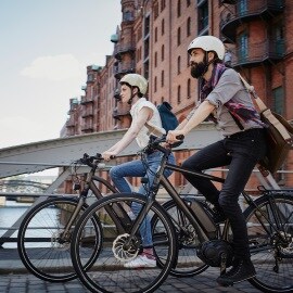 Couple riding electric bicycles at Old Warehouse District in Hamburg, Germany