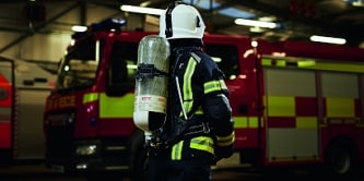 firefighters cutting into a house roof
