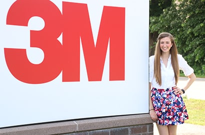3M engineer Genevieve McSpaden with a 3M sign.