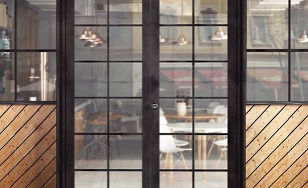 Exterior of restaurant entrance looking in through glass pane doors and windows
