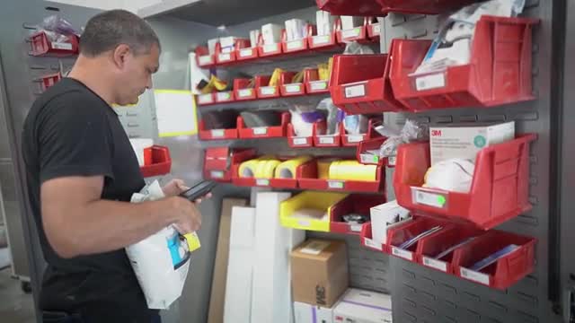 Man using repair stack in front of storage bins
