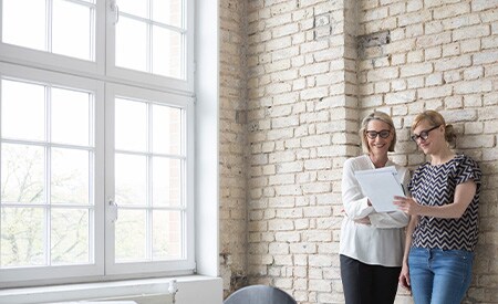 Two women who is looking on Seasons Window films offer.
