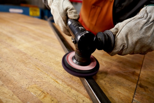 Scotch-Brite™ Clean and Strip XT Pro disc preparing a metal surface with an angle grinder