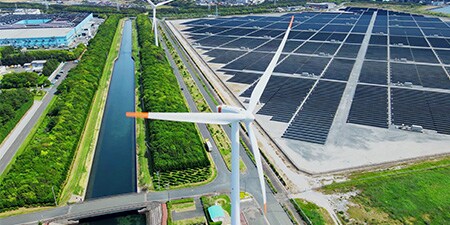 Wind turbine and solar panels in a field

