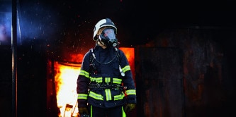 firefighters walking through a smokey building
