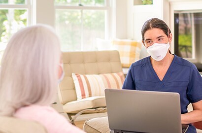 A clinician consults with a patient at home
