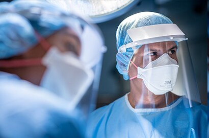 Surgical team works while wearing personal protective equipment
